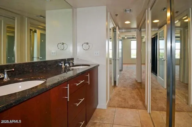 a bathroom with a granite countertop sink a large mirror and a shower