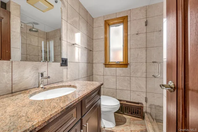 a bathroom with a granite countertop sink toilet and shower