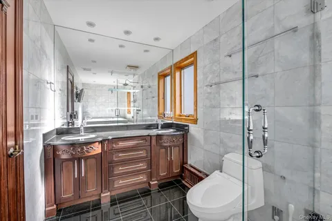 a bathroom with a granite countertop toilet sink and mirror