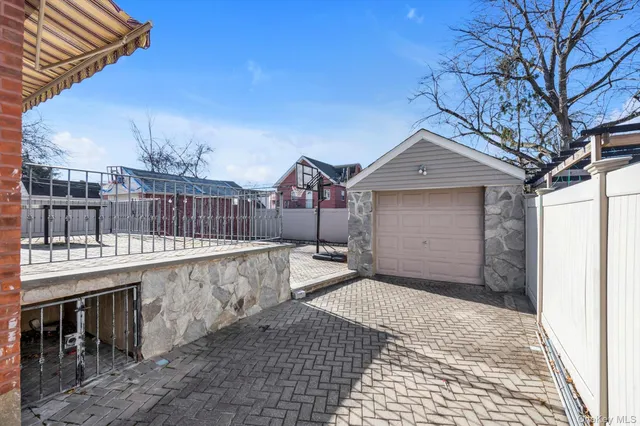 a view of a brick house with a large window and wooden fence