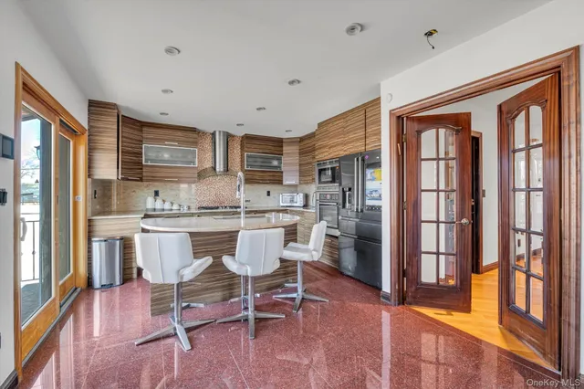 a dining room with stainless steel appliances a dining table and chairs