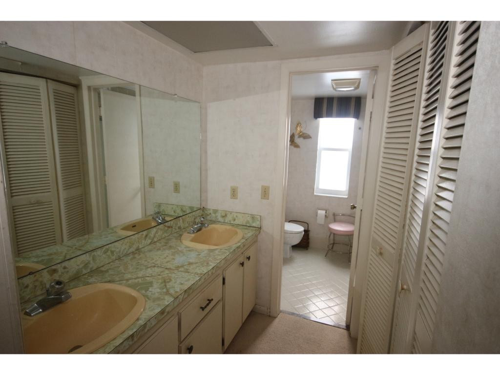 700 Teryl Road, Unit 1 Naples, FL 34112 - Photo 13 of 33 a bathroom with a granite countertop sink a toilet and a mirror