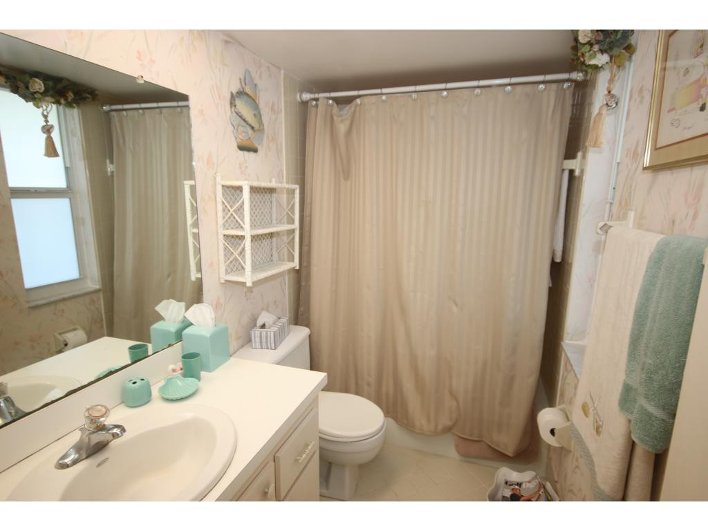 700 Teryl Road, Unit 1 Naples, FL 34112 - Photo 17 of 33 a bathroom with a sink a toilet and shower curtain