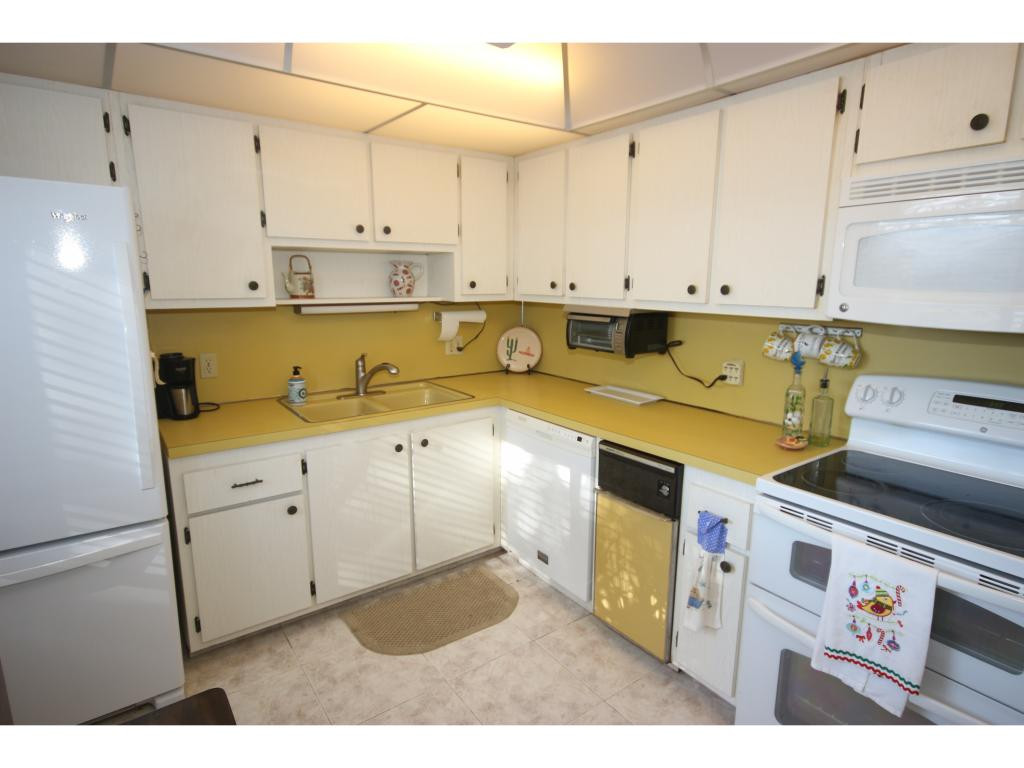 700 Teryl Road, Unit 1 Naples, FL 34112 - Photo 6 of 33 a kitchen with stainless steel appliances granite countertop a sink a stove and a refrigerator