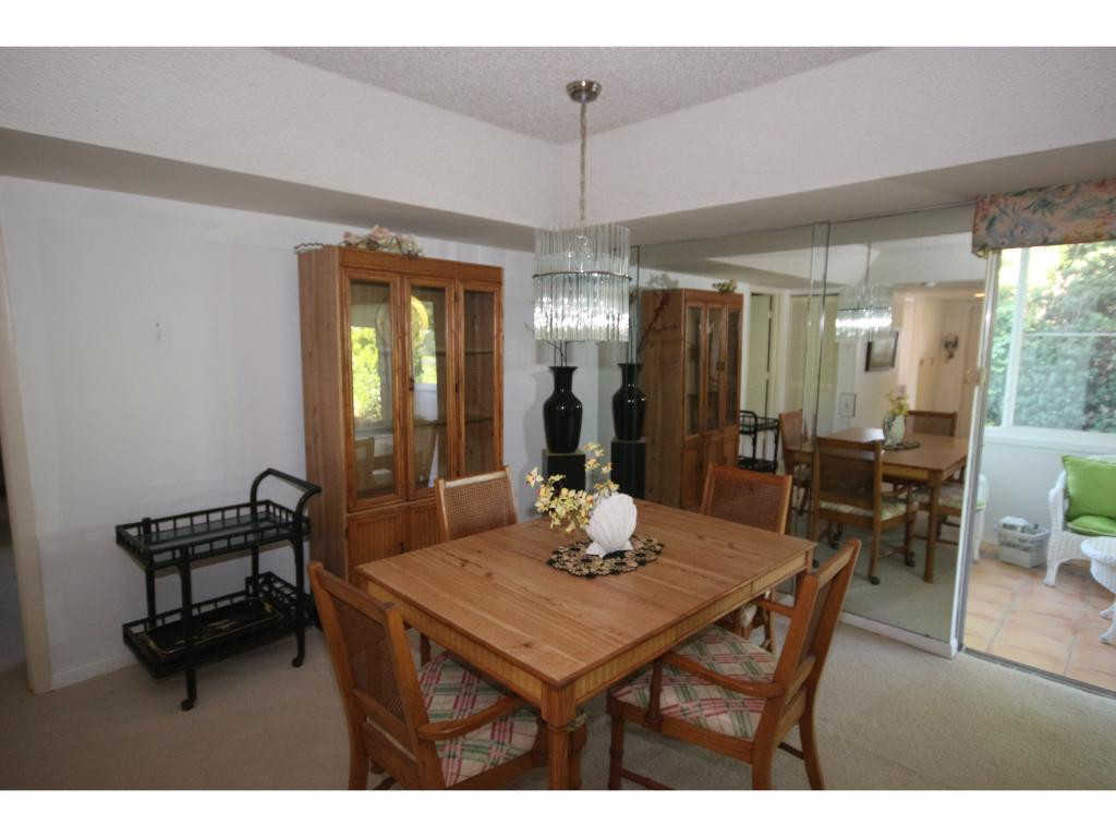 700 Teryl Road, Unit 1 Naples, FL 34112 - Photo 7 of 33 a dining room with furniture a chandelier and wooden floor