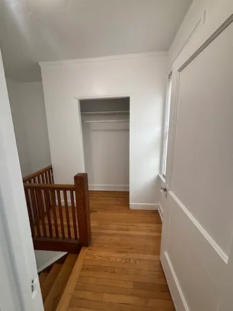 a view of a hallway with wooden floor and staircase