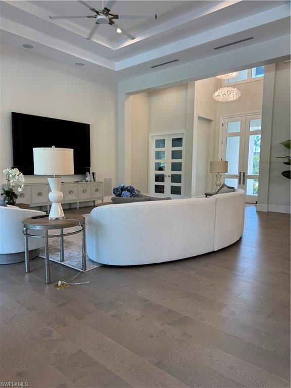569 Neapolitan Way Naples, FL 34103 - Photo 3 of 50 Living area with a ceiling fan, wood finished floors, visible vents, baseboards, and french doors