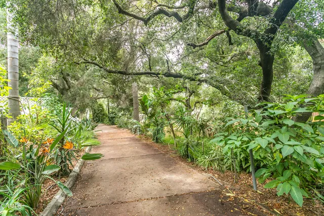 a tall yellow building with trees in front of it