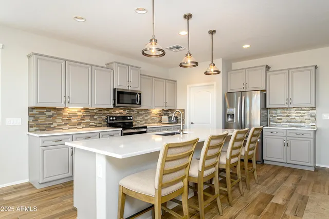 a kitchen with stainless steel appliances granite countertop a stove a sink island and a refrigerator