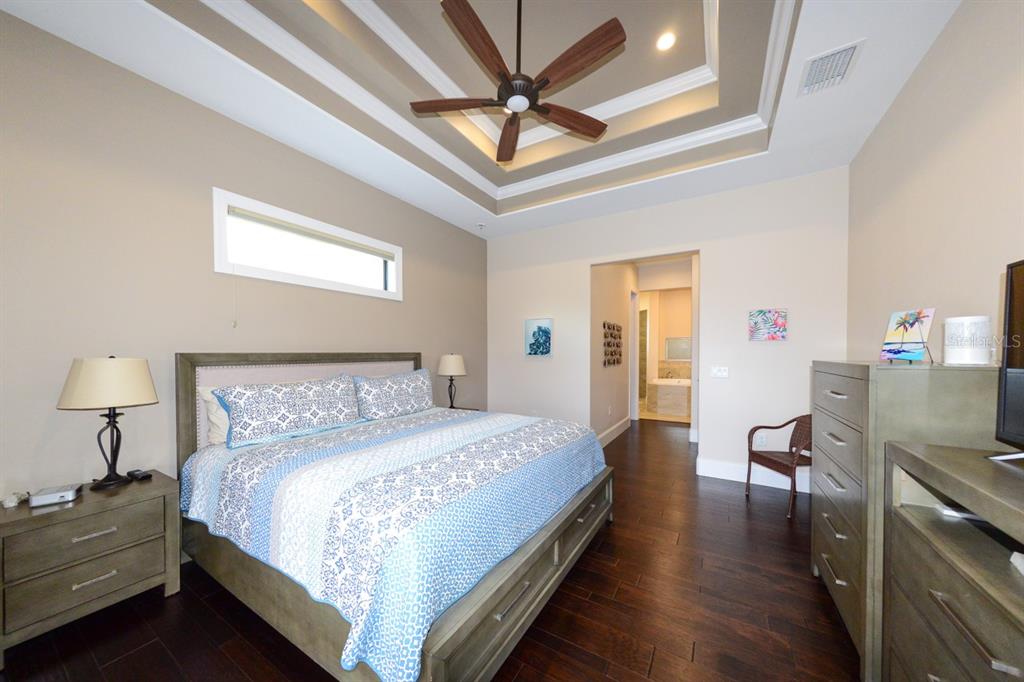 185 Colony Point Drive Punta Gorda, FL 33950 - Photo 23 of 54 a bedroom with a bed and a chandelier