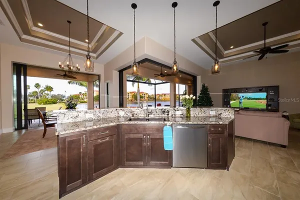 a kitchen with stainless steel appliances a sink a stove a refrigerator and island