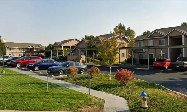 a front view of a house with a garden and parking