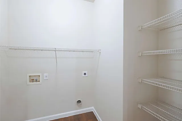 an empty room with a chandelier fan and windows