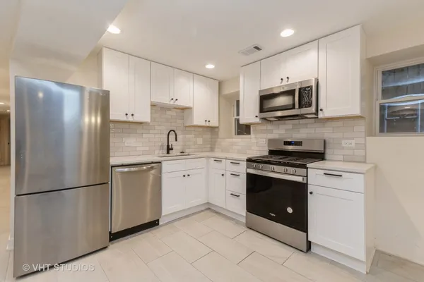 a kitchen with stainless steel appliances granite countertop a refrigerator stove a sink and a microwave