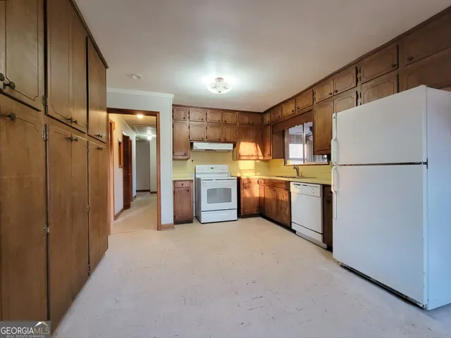 a kitchen with refrigerator a sink and white cabinets
