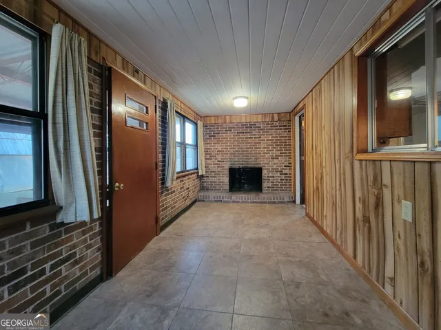 a view of empty room with fireplace and wooden floor