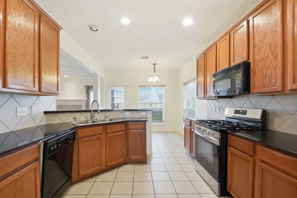 a kitchen with stainless steel appliances granite countertop a sink stove and microwave