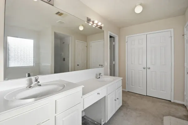 a spacious bathroom with a double vanity sink mirror and double