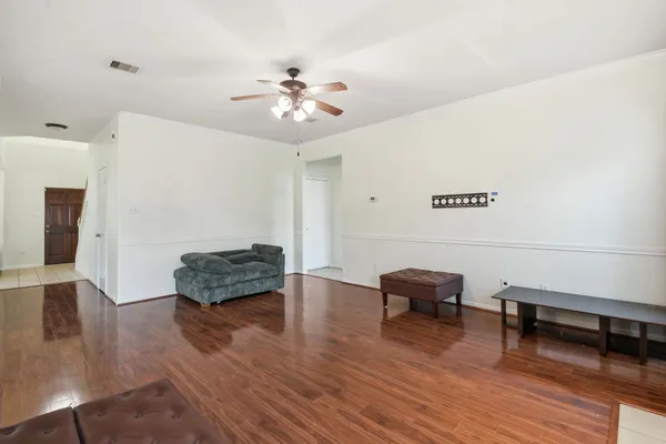 a living room with furniture and a wooden floor