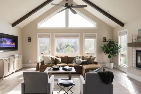 a living room with furniture a large window and a flat screen tv