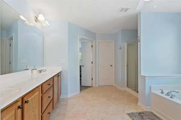 a bathroom with a double vanity sink a mirror and a bathtub
