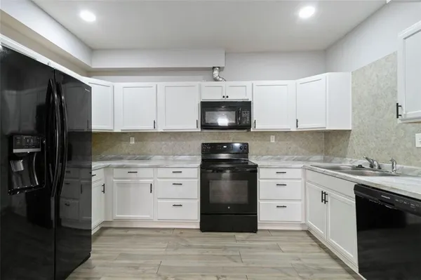 a kitchen with granite countertop a refrigerator stove and sink