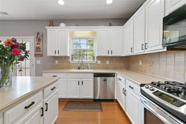 a kitchen with granite countertop a sink stove and cabinets