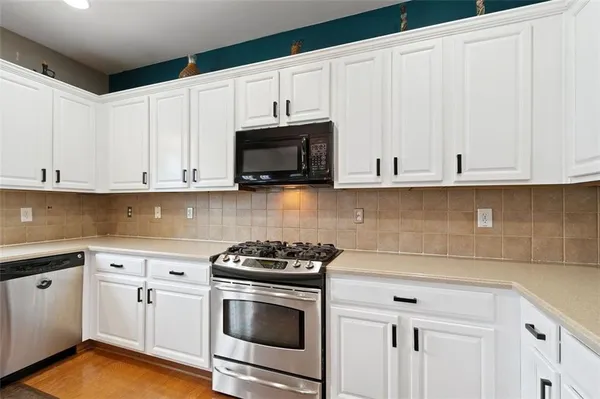a kitchen with white cabinets and white appliances
