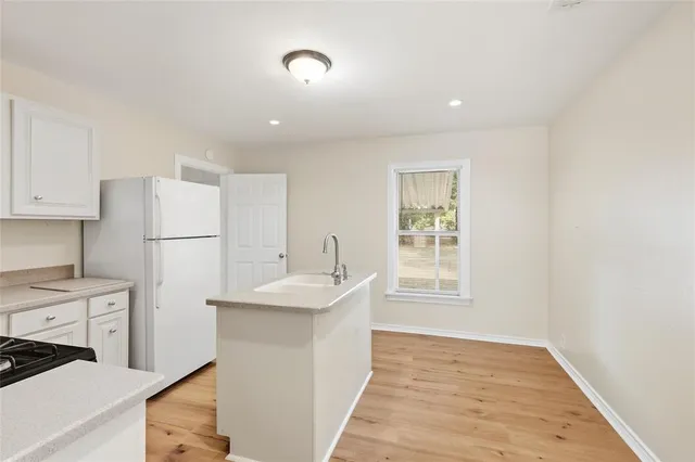 a kitchen with a sink a refrigerator freezer a stove and a window