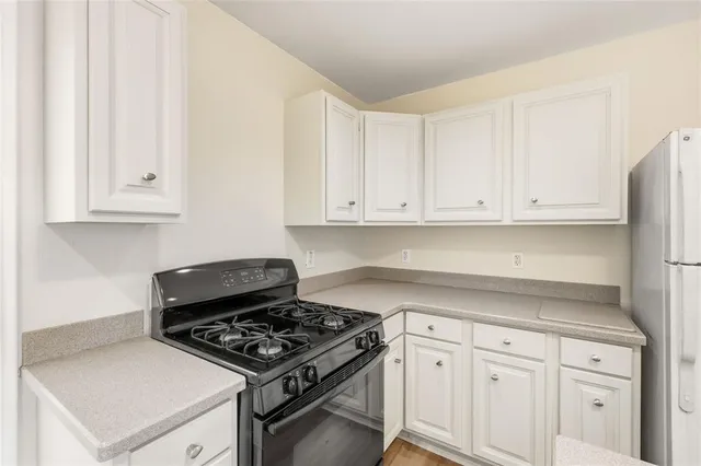 a white stove top oven sitting inside of a kitchen