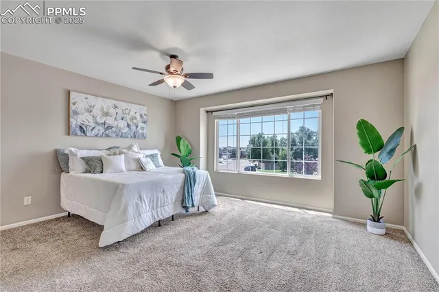 a bed sitting in a spacious bedroom next to a window