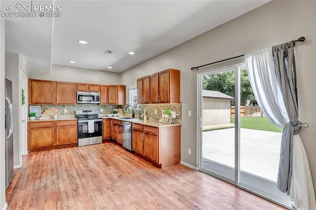 a large kitchen with a large window and stainless steel appliances