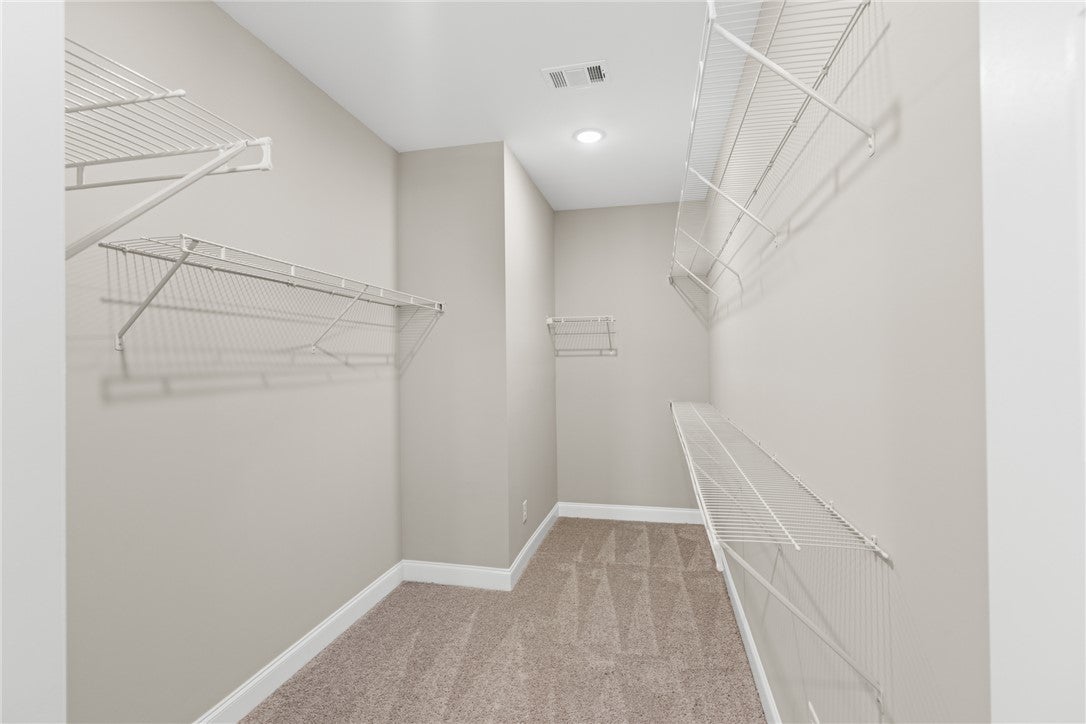 320 Coscoroba Road Auburn, AL 36832 - Photo 11 of 27 This spacious walk-in closet offers ample storage with versatile wire shelving and comfortable carpet flooring.