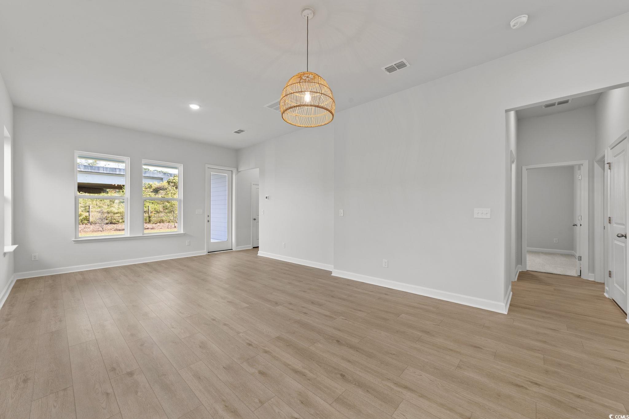 771 Ebb Tide Road Little River, SC 29566 - Photo 22 of 35 Empty room with light wood-style floors, recessed lighting, and a chandelier