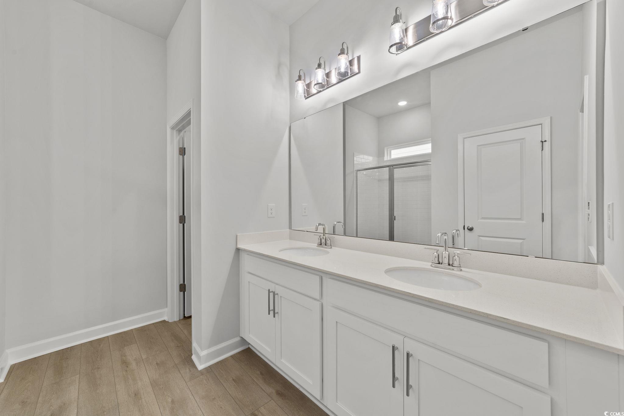 771 Ebb Tide Road Little River, SC 29566 - Photo 28 of 35 Full bathroom with double vanity, a shower stall, and light wood finished floors