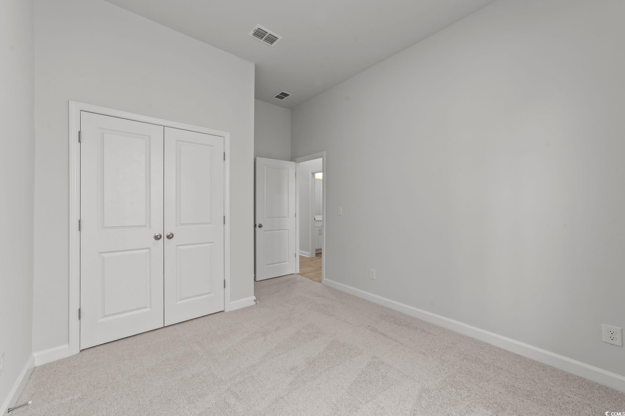 771 Ebb Tide Road Little River, SC 29566 - Photo 34 of 35 Unfurnished bedroom featuring light carpet and a closet