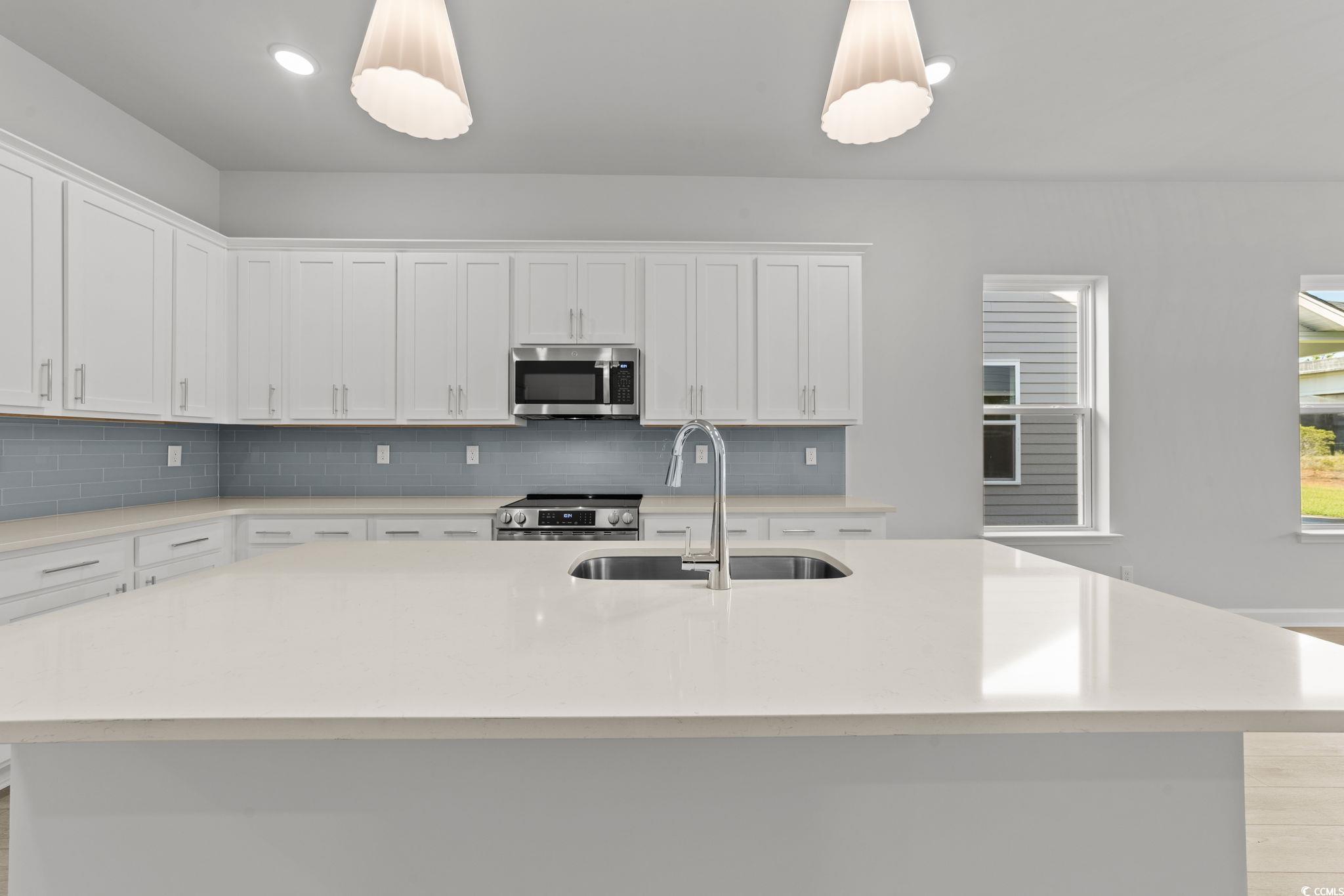 771 Ebb Tide Road Little River, SC 29566 - Photo 35 of 35 Kitchen featuring white cabinetry, a kitchen island with sink, stainless steel appliances, light stone counters, and recessed lighting