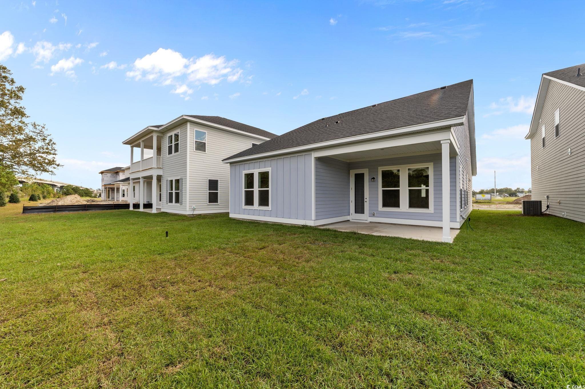 771 Ebb Tide Road Little River, SC 29566 - Photo 4 of 35 Rear view of house featuring a lawn, a patio, roof with shingles, and board and batten siding