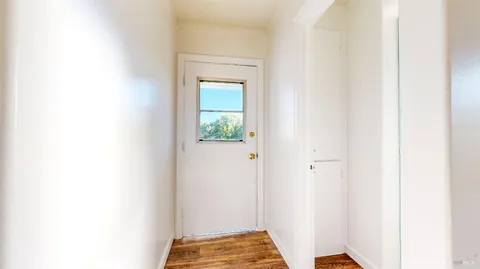 a view of a room with wooden floor and a window