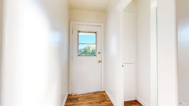 a view of a room with wooden floor and a window