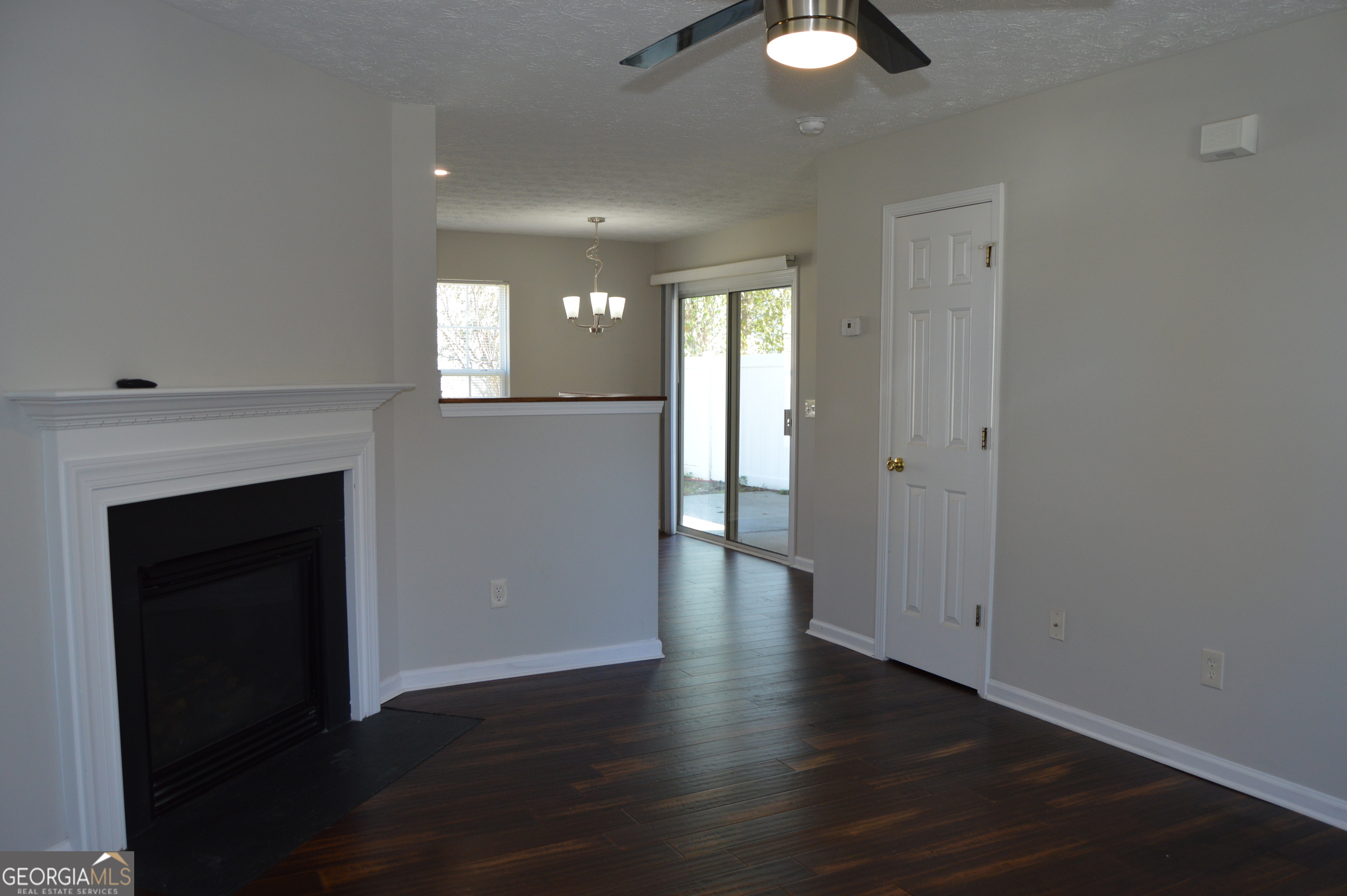 5765 Ridge Stone Way Cumming, GA 30041 - Photo 21 of 22 an empty room with wooden floor fireplace and windows