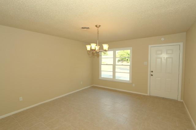 1621 68th Street Lubbock, TX 79412 - Photo 2 of 2 en empty room with windows and chandelier