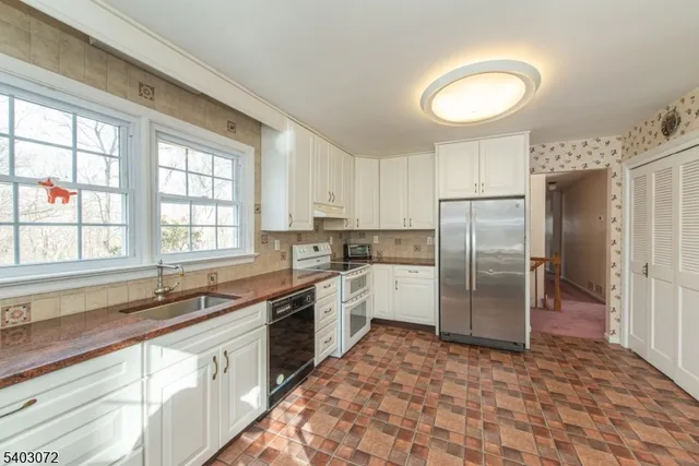 a kitchen with a refrigerator sink and cabinets