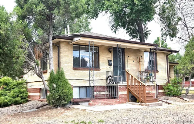 a front view of a house with a tree