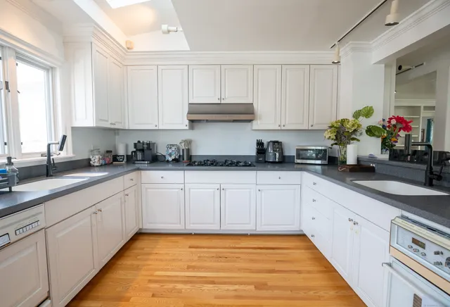 a kitchen with granite countertop white cabinets and white appliances