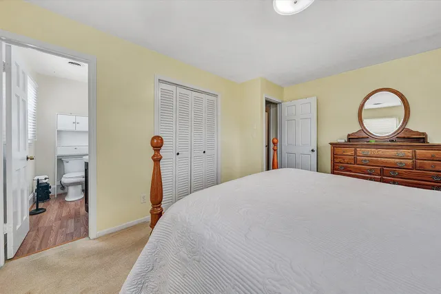 a bedroom with a bed and a dresser with mirror