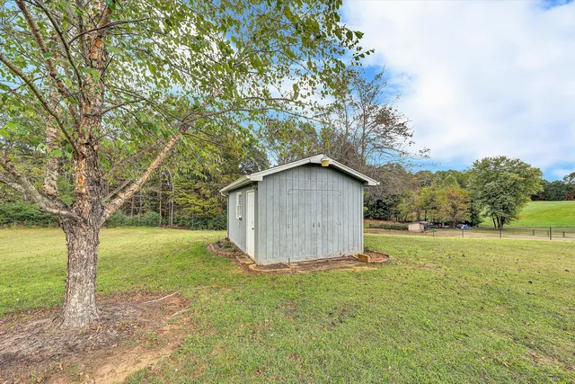 a view of a house with a big yard and a large tree