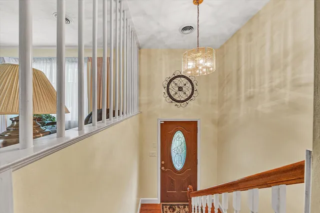 a view of a hallway with wooden floor and windows