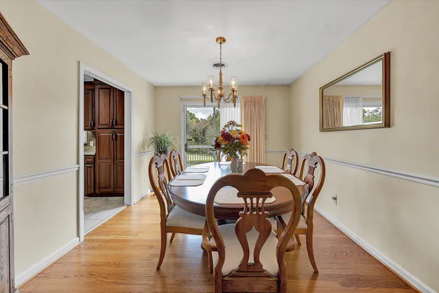a dining room with furniture a chandelier and wooden floor