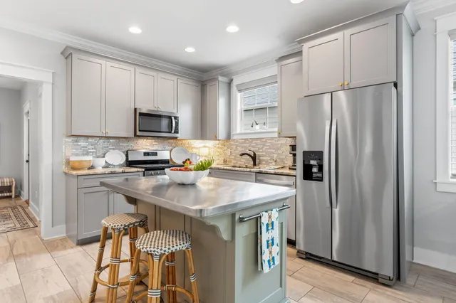 a kitchen with a refrigerator a microwave a sink and cabinets